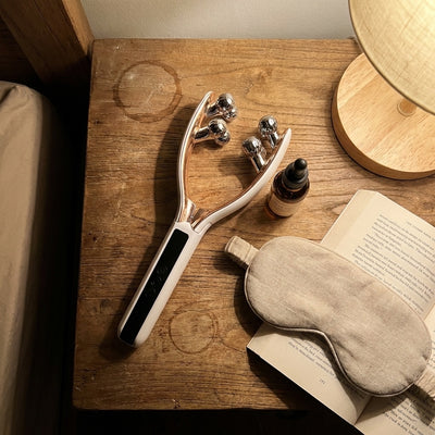Voirelle Hush on a nightstand with face oil, a sleep mask and a book