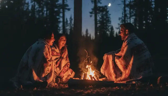 Friends sitting around a campfire at dusk